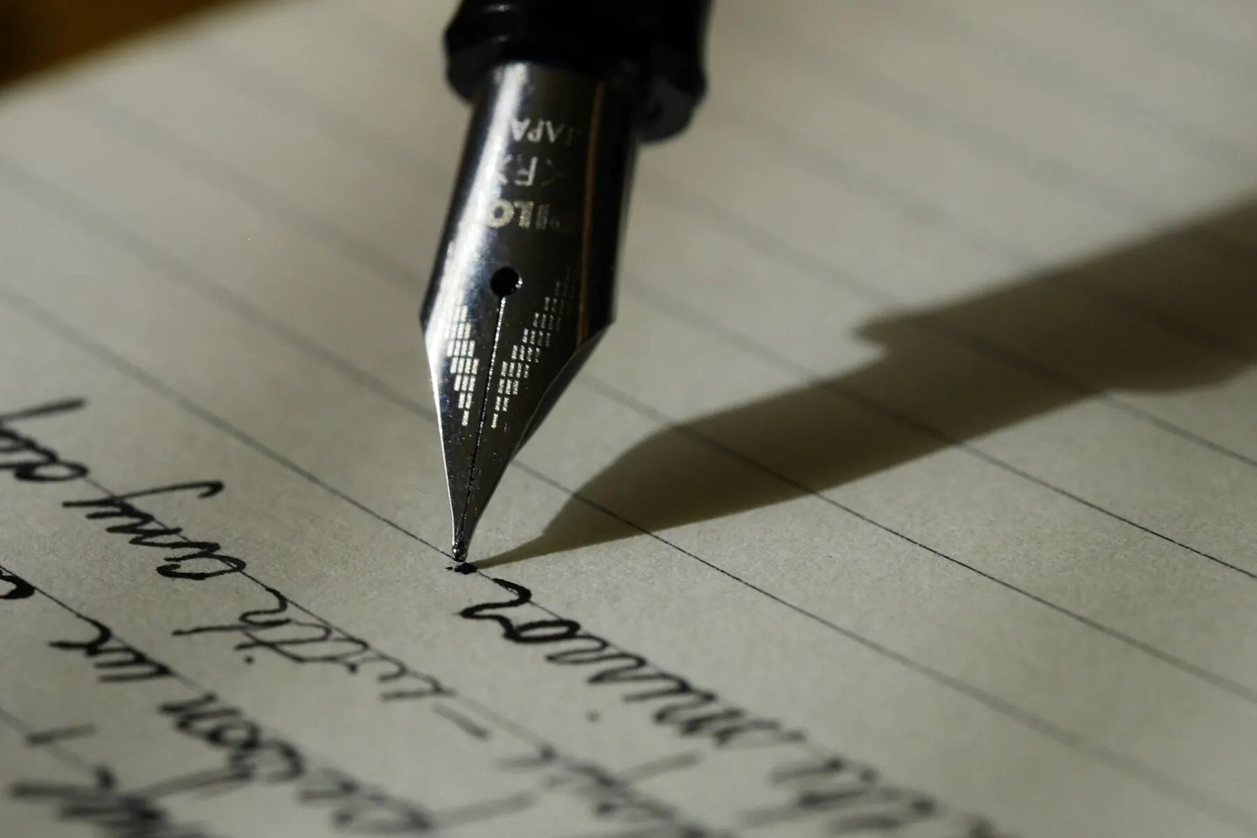 A fountain pen moving across a handwritten page.
